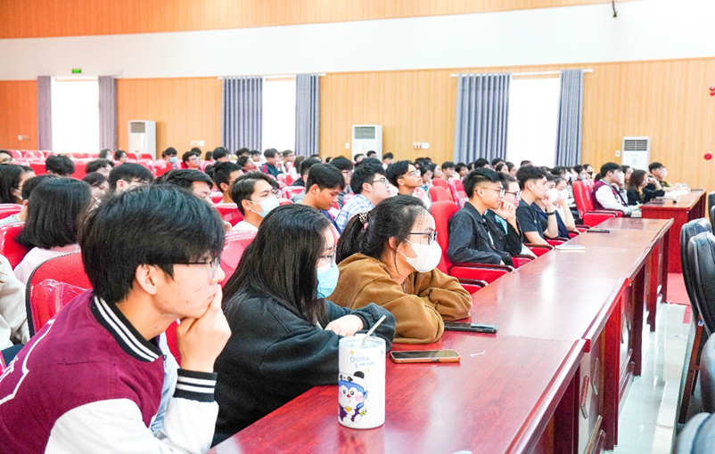 A group of people sitting in a lecture hall

Description automatically generated